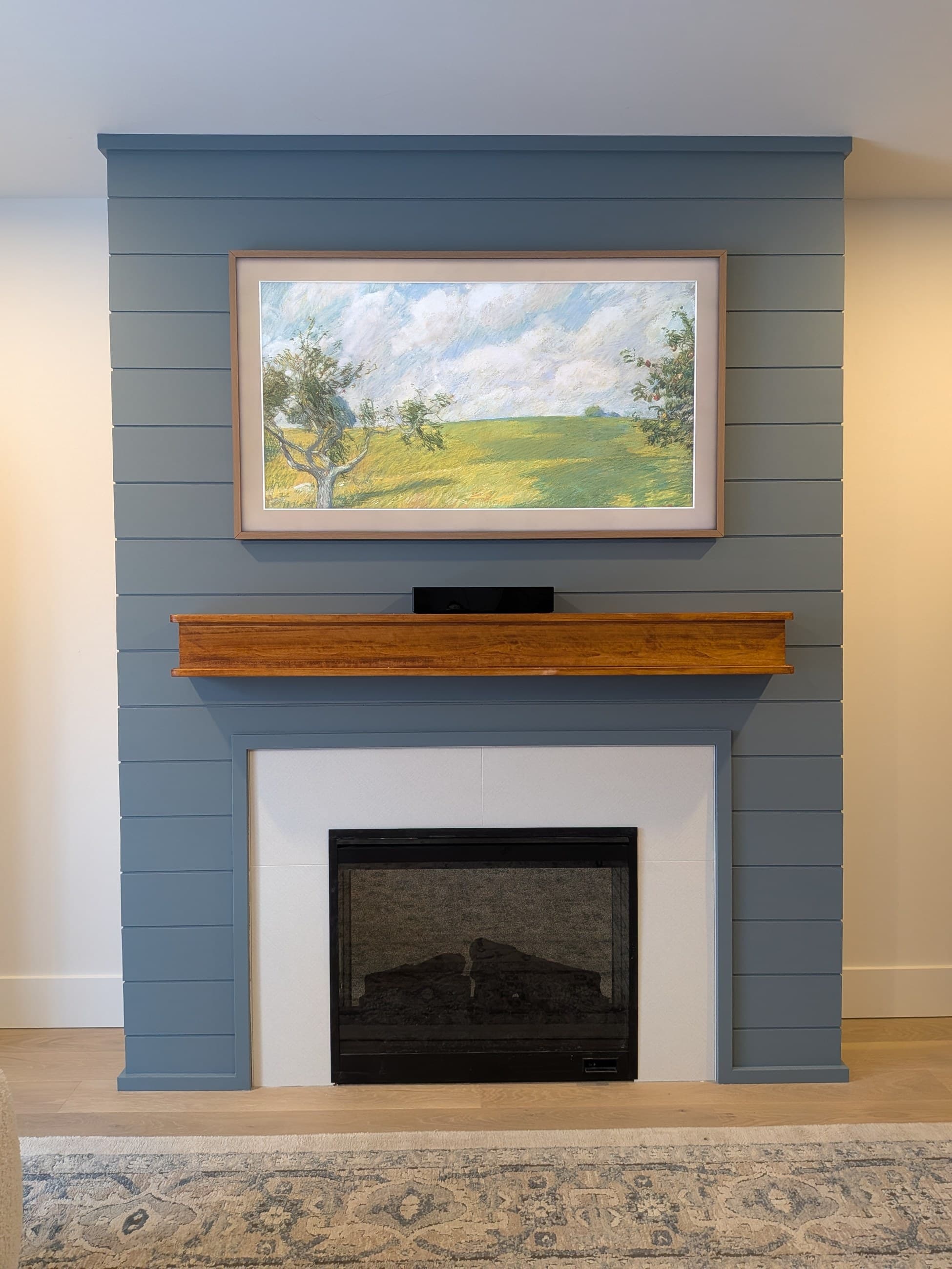 Finished blue fireplace feature wall in the Armstrong basement