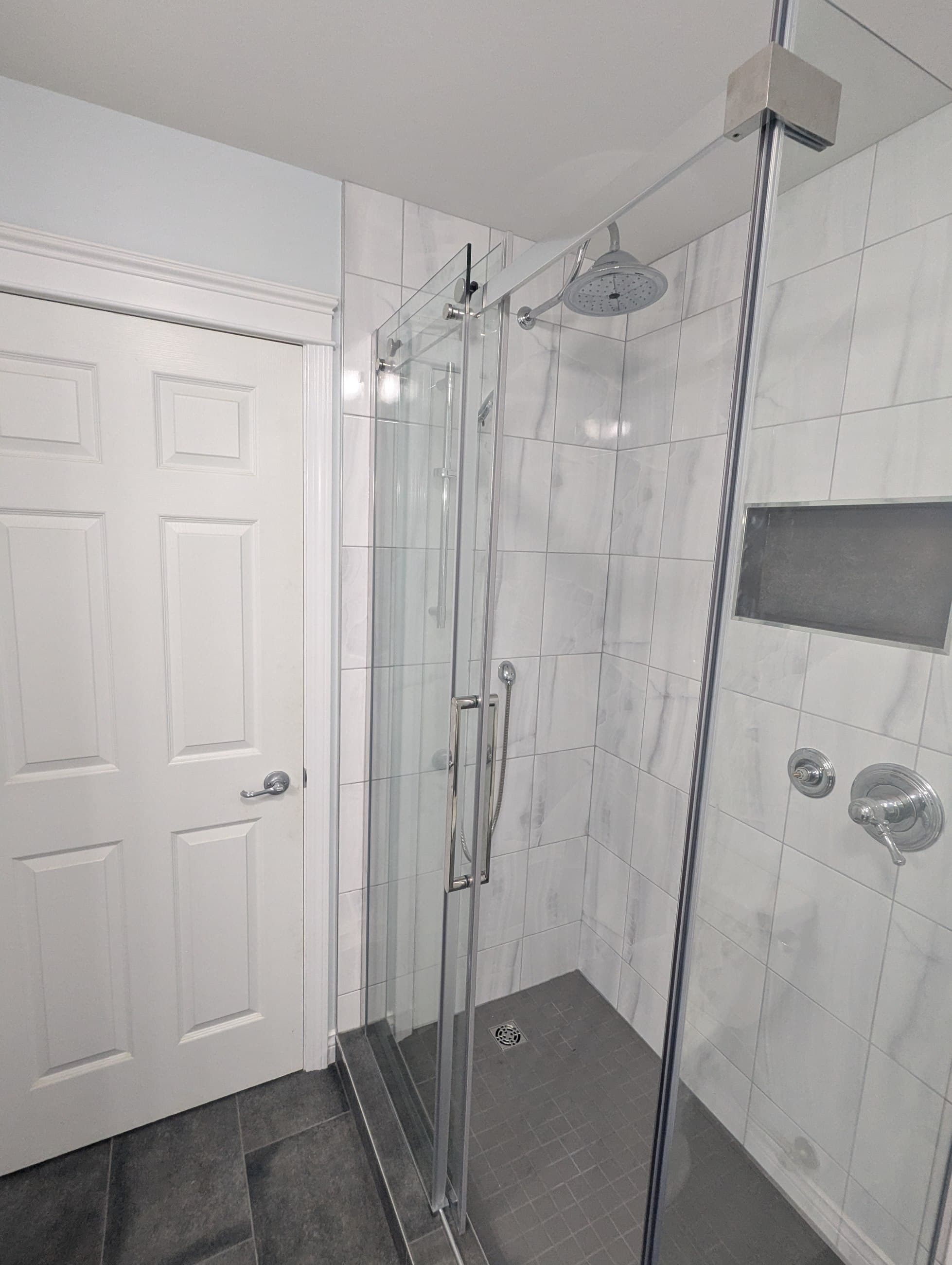 Close view of the finished Taylor bathroom shower, niche, chrome fixtures, and tile
