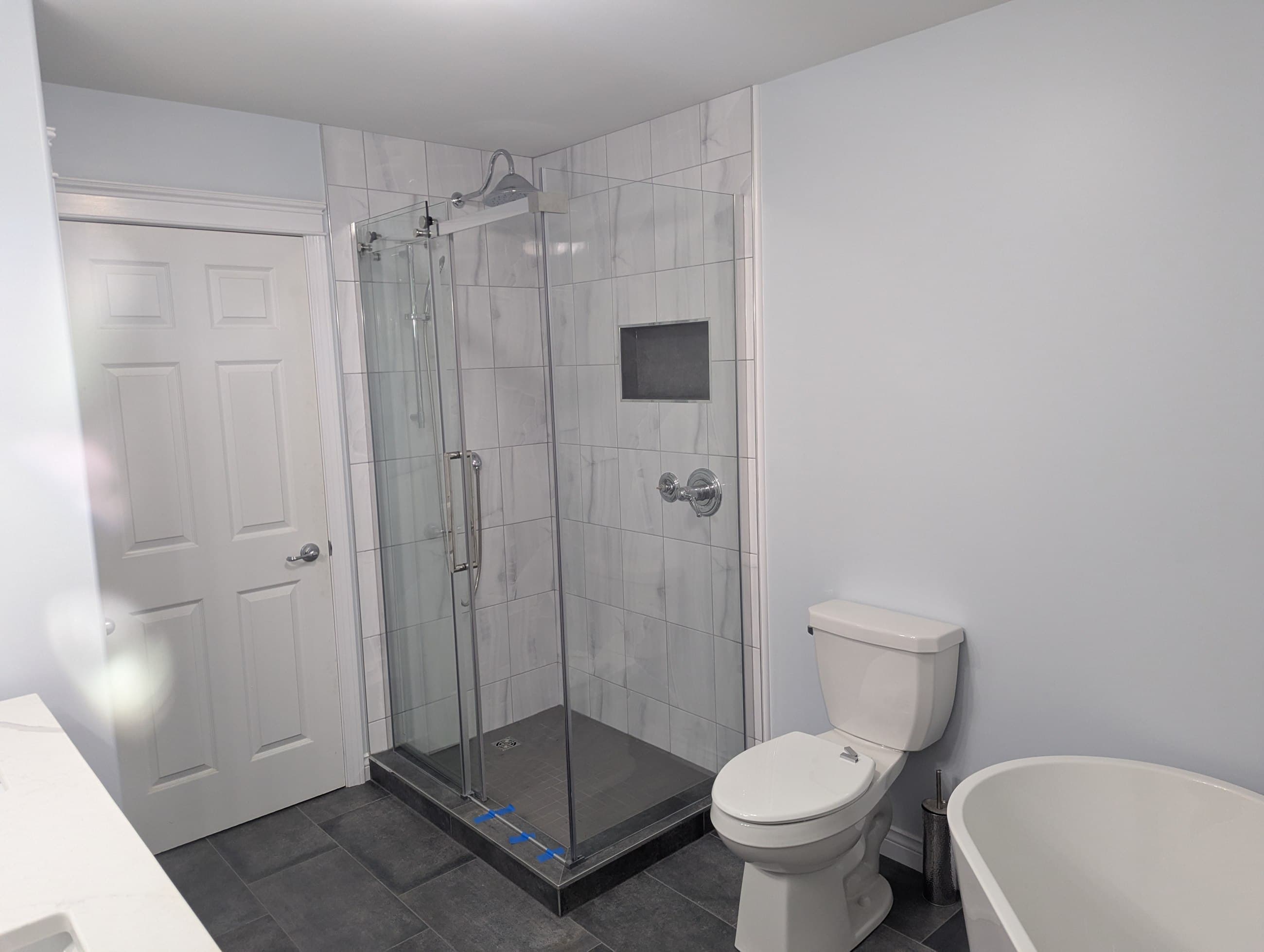 Taylor bathroom glass shower with marble-look tile and recessed niche